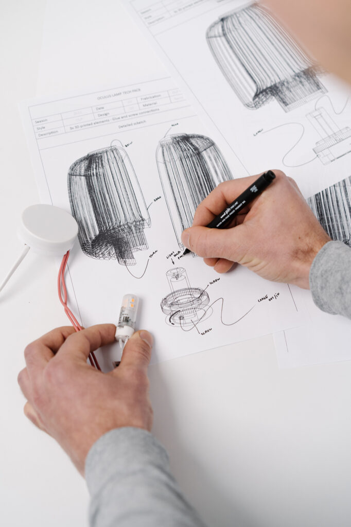 Julian Gamper sketching on technical sheet of lamp design